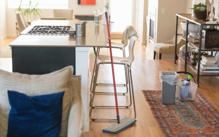 Cleaning supplies and mop in a bright, tidy kitchen for professional cleaning service.