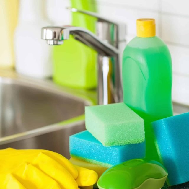 Bright colorful cleaning tools and sponges on kitchen countertop.