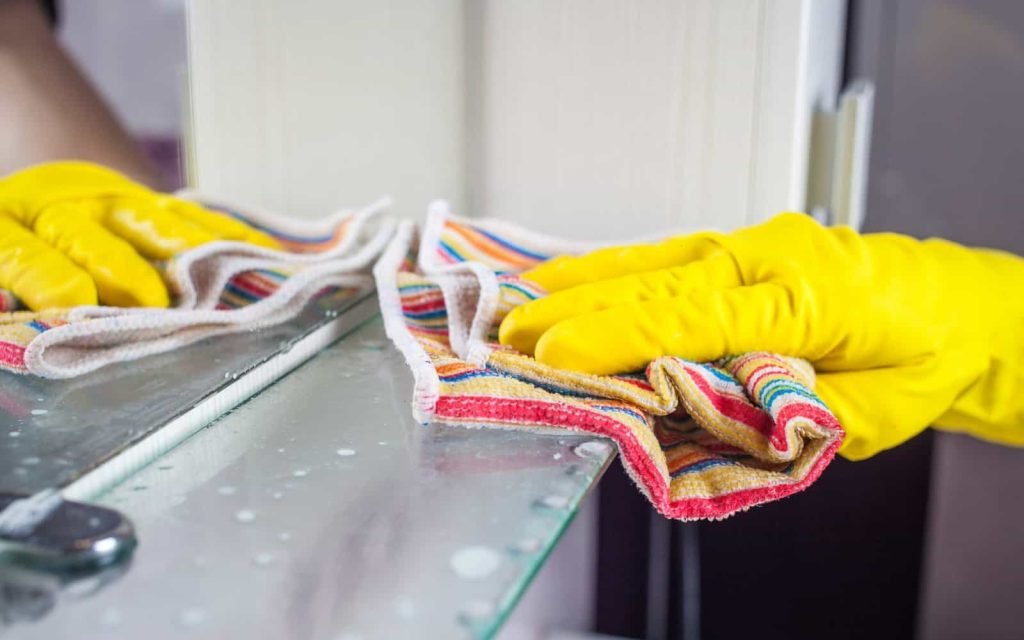 Clean tile floor with microfiber cloth and yellow gloves for spotless results.