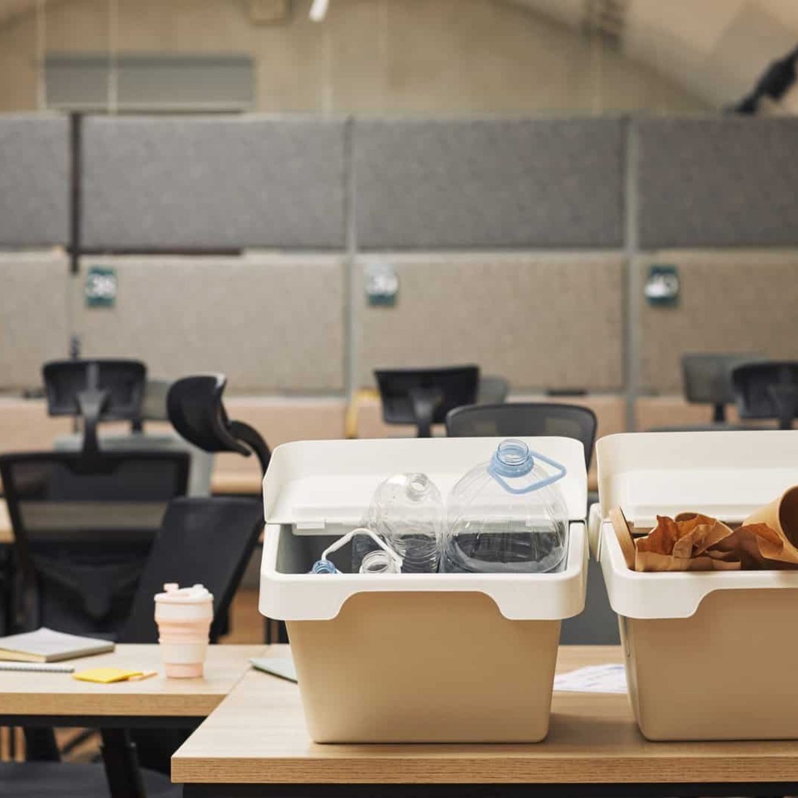 Clean office with recycling bins for bottles and paper waste, promoting eco-friendly waste disposal.